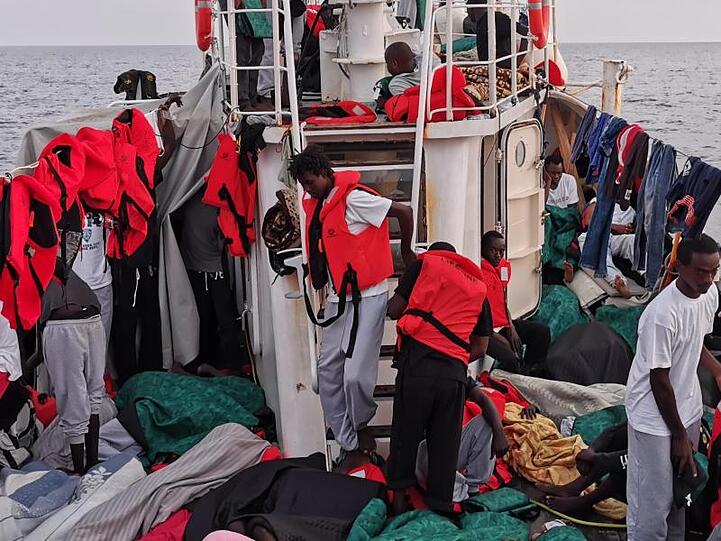 Rund 100 Migranten stehen und liegen in den frühen Morgenstunden eng gedrängt an Deck des Rettungsschiff "Eleonore". Foto: Johannes Filous