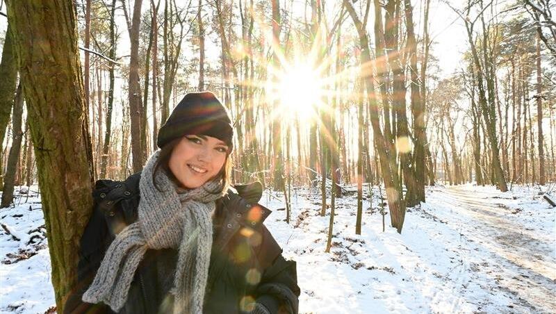 Eine Frau genießt den Wintertag in der Natur. Um München herum gibt es Möglichkeiten en masse, um ein entspanntes Wochenende zu verbringen.