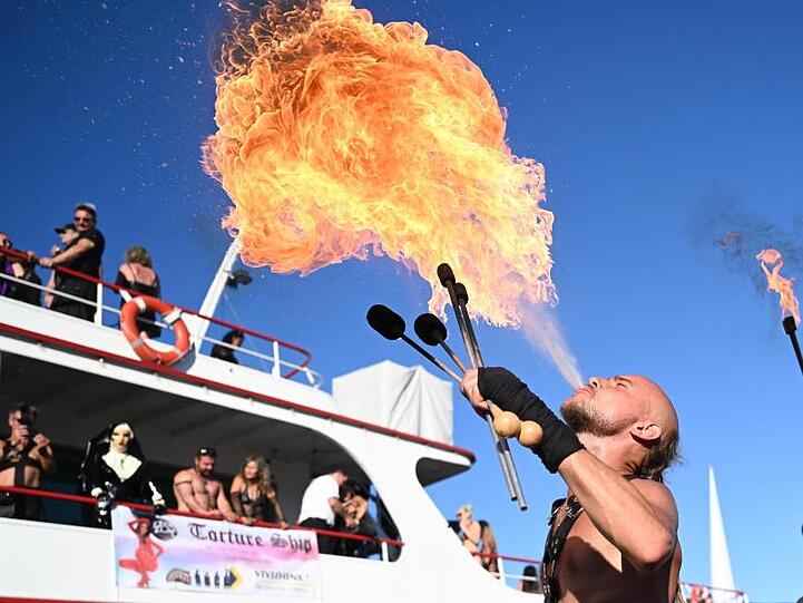 Ein Teilnehmer des "Torture Ship" im letzten Jahr spuckt am Hafensteg Feuer. Foto: Felix Kästle/dpa/Archivbild