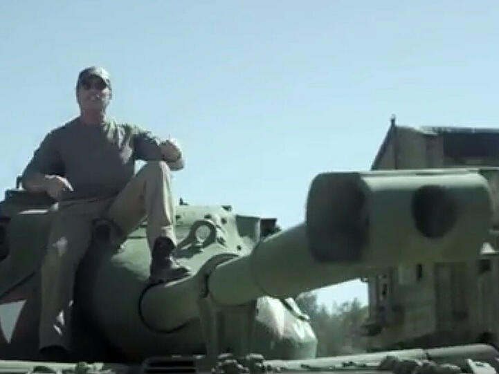 Arnold Schwarzenegger sitzt auf seinem Panzer