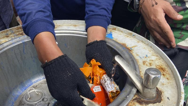 Ein Mitglied der indonesischen Marine inspiziert ein Teil des Flugdatenschreibers.