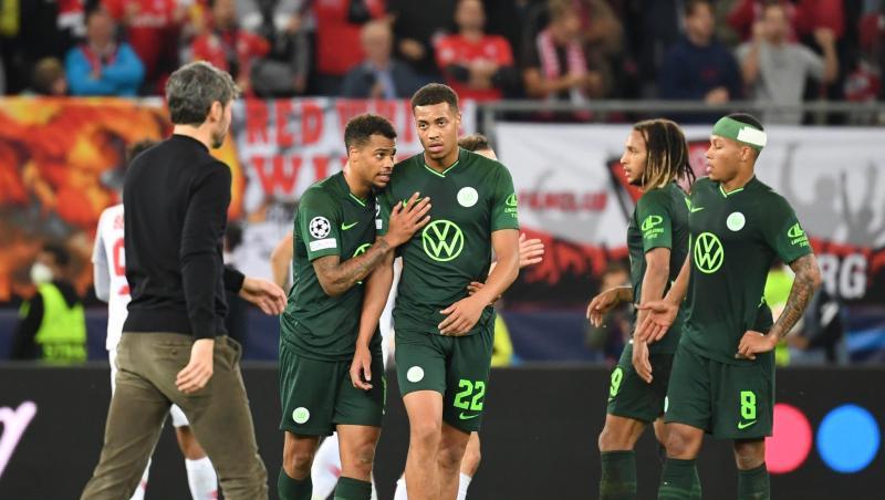 Wolfsburgs Trainer Mark van Bommel (l) geht nach dem Spiel über den Platz zu seinen Spielern.