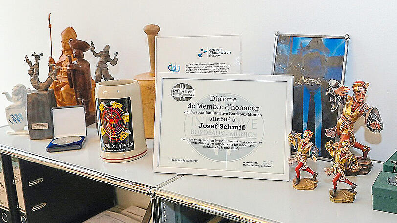 Links ein Wiesn-Maßkrug und eine Ehrenmünze der Schausteller, rechts Moriskentänzer. Die Bürgermeistergeschenke stehen jetzt in der Kanzlei.