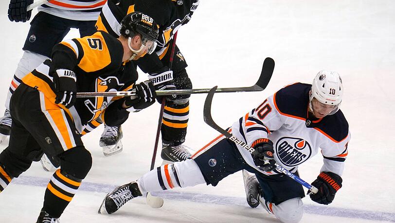 Derek Ryan (r) von den Oilers fällt nach einem Zusammenstoß mit Penguins' Mike Matheson auf das Eis.