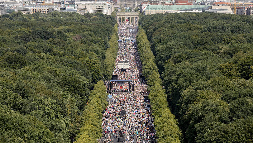 Dicht gedrängt und ohne die Abstandsregeln zu beachten stehen Tausende Menschen bei einer Kundgebung gegen die Corona-Beschränkungen auf der Straße des 17. Juni in Berlin. Dicht gedrängt und ohne die Abstandsregeln zu beachten stehen Tausende Menschen bei einer Kundgebung gegen die Corona-Beschränkungen auf der Straße des 17. Juni in Berlin.
