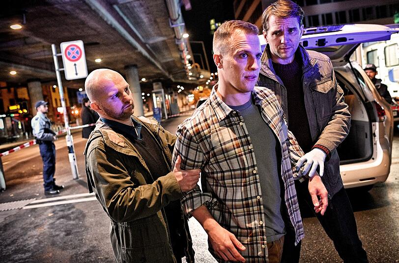 Hauptmann Furrer (Pierre Kiwitt, rechts) und sein Kollege Urs Aeggi (Yves W&uuml;thrich, links) nehmen den des Mordes verd&auml;chtigen Taxifahrer J&uuml;rg Zollinger (Tim Kalkhof) fest. Doch Anwalt Borchert glaubt nicht, dass er der T&auml;ter ist.