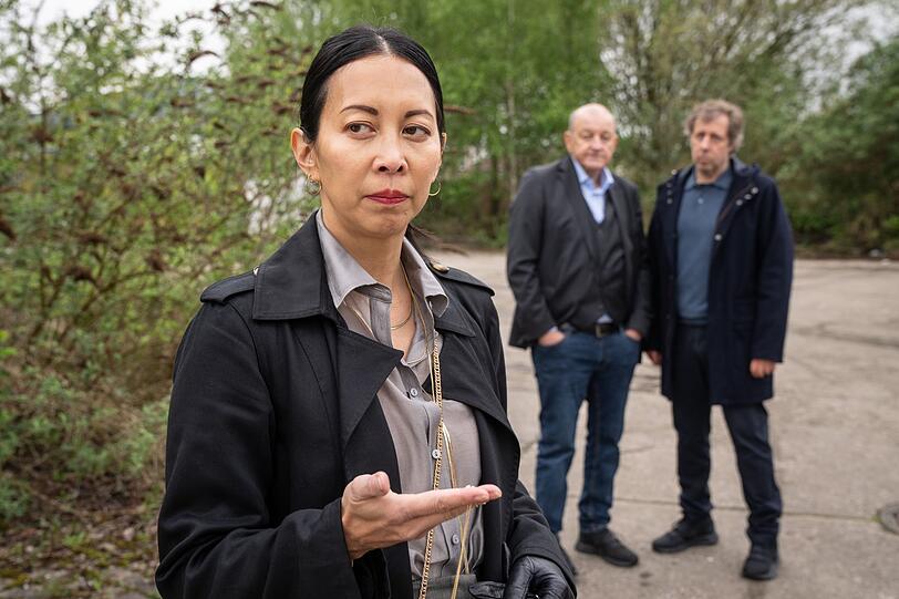 Agenturchefin Sophie Dragon (Minh-Khai Phan-Thi) findet am Tatort eine goldene Kette, während Wilsberg (Leonard Lansink, Mitte) und Ekki Talkötter (Oliver Korittke) das Geschehen verfolgen. Agenturchefin Sophie Dragon (Minh-Khai Phan-Thi) findet am Tatort eine goldene Kette, während Wilsberg (Leonard Lansink, Mitte) und Ekki Talkötter (Oliver Korittke) das Geschehen verfolgen.