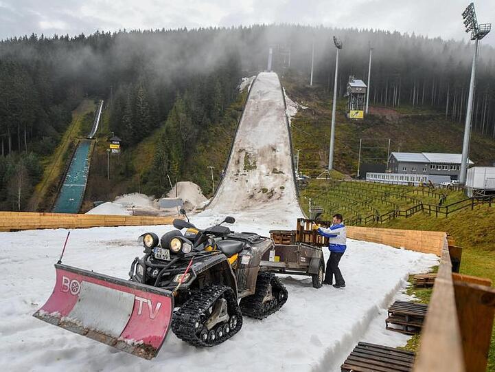 Der Hang der Skisprungschanze im Schwarzwald sieht aus wie ein Schlachtfeld: Grüne und graue Flecken, Matsch, Dreck und ein Rest von Kunstschnee.
