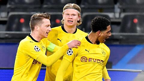 Dortmunds Jude Bellingham (r) jubelt nach seinem Treffer zum 1:0 mit seinen Teamkollegen Erling Haaland (M) und Marco Reus.