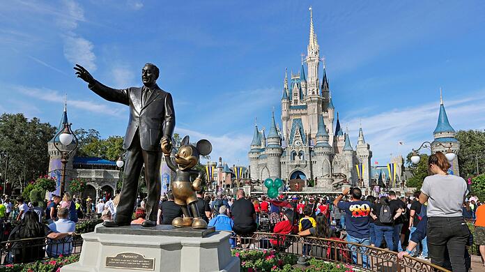 Eine Statue von Walt Disney und Micky Maus  vor dem Cinderella-Schloss im Magic Kingdom von Walt Disney World in Florida.