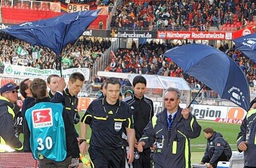Schiedsrichter Michael Weiner (Mitte) und seine Assistenten mussten am 19. März im easyCredit-Stadion vor diversen Wurfgeschossen geschützt werden. Juristisches Nachspiel garantiert.
