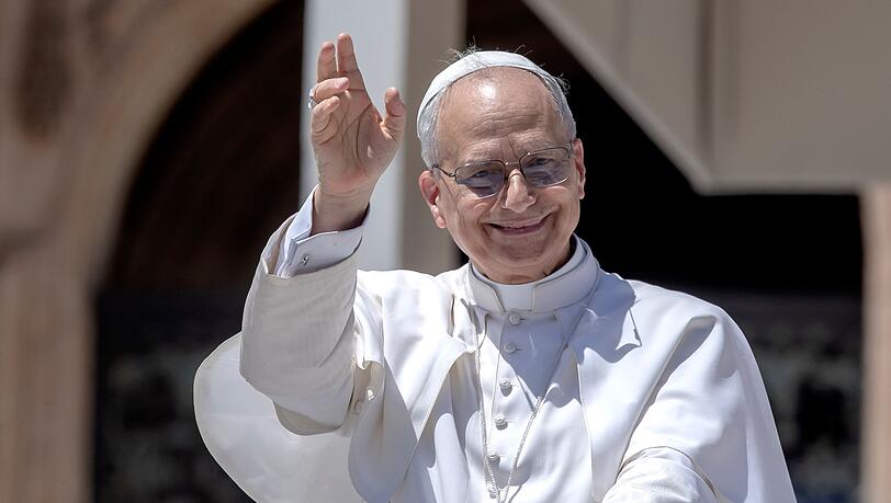 Papst Leo XIV. winkt, während er mit dem Papamobil nach seiner wöchentlichen Generalaudienz über den Petersplatz im Vatikan fährt. Papst Leo XIV. winkt, während er mit dem Papamobil nach seiner wöchentlichen Generalaudienz über den Petersplatz im Vatikan fährt.
