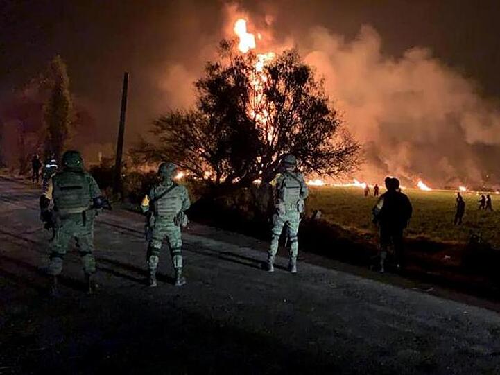 Streitkräfte der Armee sichern den Ort, an dem eine Benzinleitung explodiert ist.
