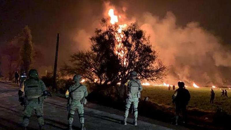 Streitkräfte der Armee sichern den Ort, an dem eine Benzinleitung explodiert ist. Streitkräfte der Armee sichern den Ort, an dem eine Benzinleitung explodiert ist.