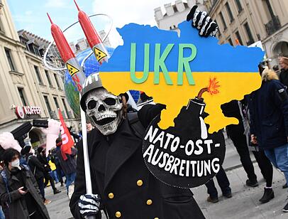 Ein Demonstrant mit Stahlhelm und Totenkopfmaske nimmt 2022 bei einer Demonstration gegen die Sicherheitskonferenz am Stachus teil. Ein Demonstrant mit Stahlhelm und Totenkopfmaske nimmt 2022 bei einer Demonstration gegen die Sicherheitskonferenz am Stachus teil.