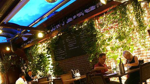 Blaue Stunde: Im Wintergarten geht es ruhiger zu als vorn im Lokal. Die meisten Gäste hier kommen später zum Tanzen und Feiern vor.