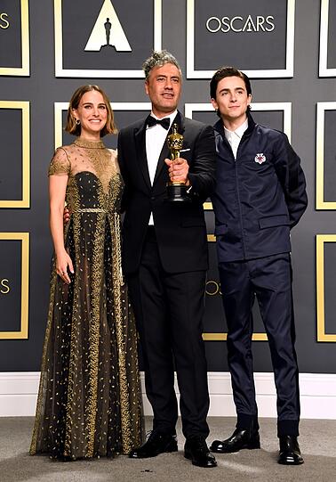 Die beiden Laudatoren Natalie Portman und Timothee Chalamet mit Preisträger Taika Waititi