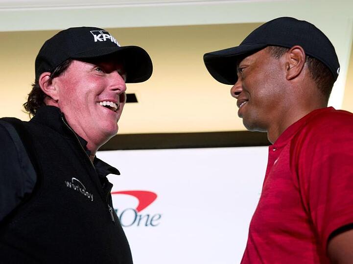 Phil Mickelson (l) und Tiger Woods spielen um Millionen gegeneinander.