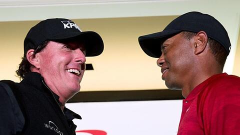 Phil Mickelson (l) und Tiger Woods spielen um Millionen gegeneinander.