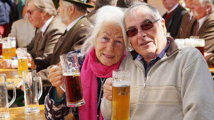 Genießen Sonne und eine kühle Halbe: Besucher am Bierbrunnen vorm Brauerhaus.