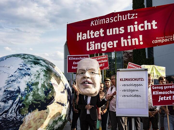 Demonstranten stehen vor Beginn Sitzung des Kabinettausschusses vor dem Bundeskanzleramt.