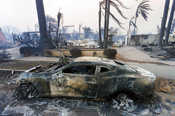Ein verbranntes Auto parkt vor einem Haus, das vom Palisades-Feuer zerstört wurde.