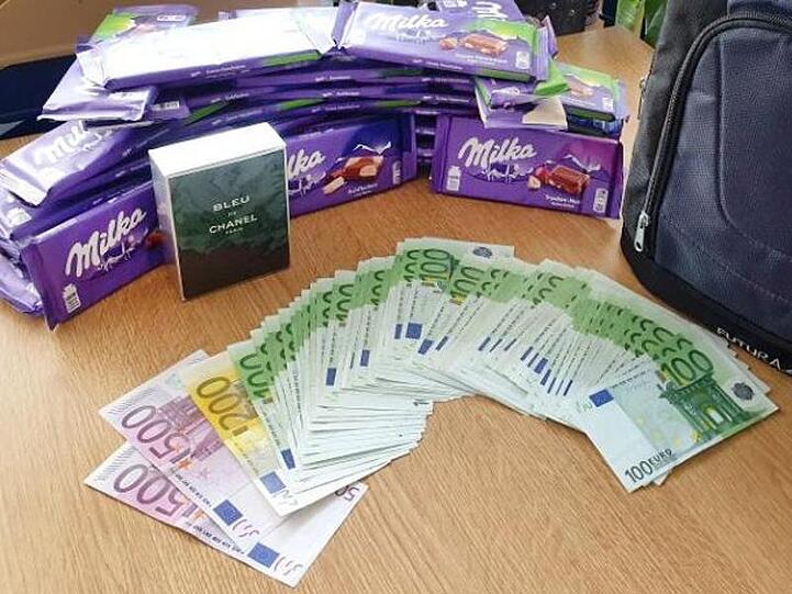 Bargeld und Schokolade liegen bei der Bundespolizei auf einem Tisch. Foto: Bundespolizeiinspektion München