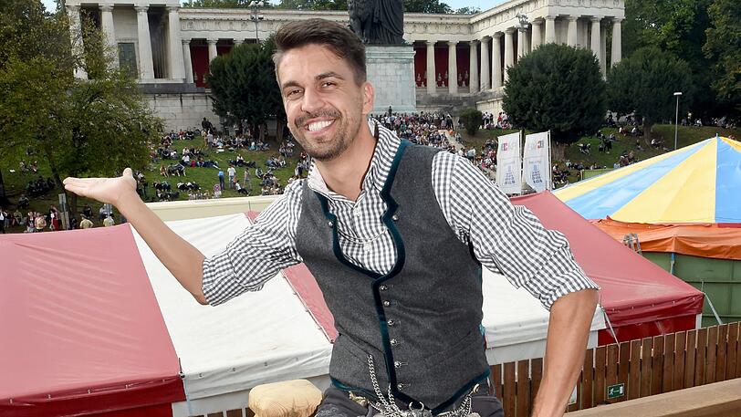 Fesch und fröhlich: Trachten-Designer Daniel Fendler posiert in Käfers Wiesn-Schänke.