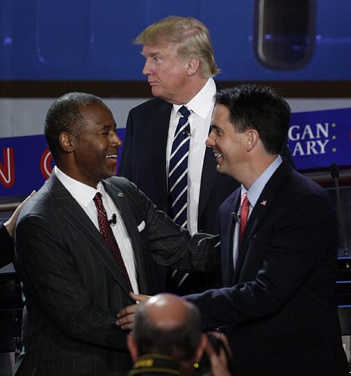 Die US-Präsidentschaftskandidaten Ben Carson (links) und Scott Walker (rechts) beim Shakehands, im Hintergrund Donald Trump.