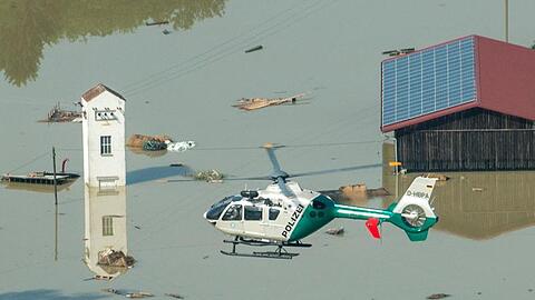 Ein Polizeihubschrauber fliegt nahe Deggendorfer Ortsteil Fischerdorf über dem Hochwasser. Foto: Armin Weigel/Archiv