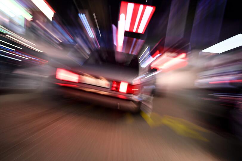 Ein Fahrer fährt mit seinem getunten Auto über einen Parkplatz eines Schnellrestaurants. Fans getunter Autos treffen sich traditionell am Karfreitag in ganz NRW.