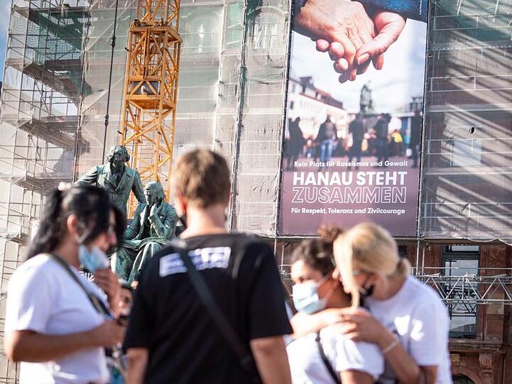 Ein neues Banner mit der Aufschrift "Kein Platz für Rassismus und Gewalt - Hanau steht zusammen für Respekt, Toleranz und Zivilcourage" hängt an der Fassade des Rathauses vor dem Gebrüder-Grimm-Denkmal.