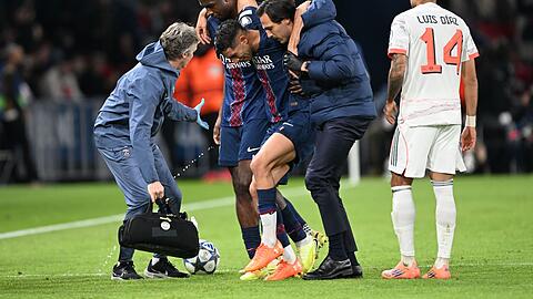 Auf Betreuer gestützt wird der am Fuß verletzte PSG-Spieler Achraf Hakimi (M) vom Platz geführt.