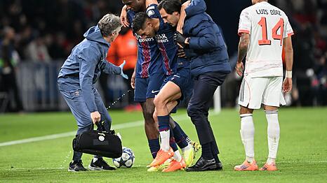 Auf Betreuer gestützt wird der am Fuß verletzte PSG-Spieler Achraf Hakimi (M) vom Platz geführt.