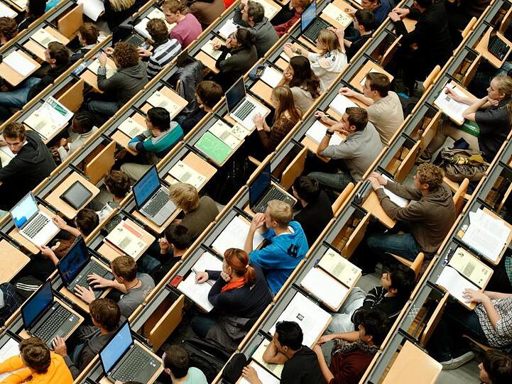 Studenten sitzen in einem großen Hörsaal. Foto: Peter Kneffel/Archivbild