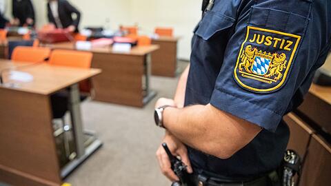Ein Justizbeamter steht zu Beginn eines Prozesses im Sitzungssaal des Landgerichts München II. (Symbolbild)