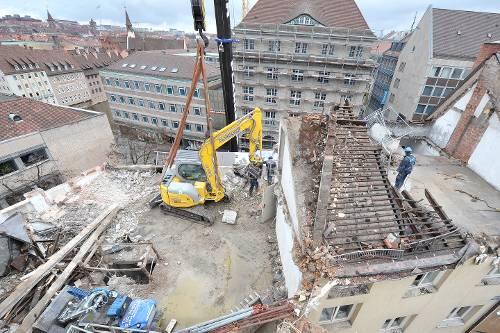Damit er nicht abstürzt: Der Abriss-Bagger hängt an einem Autokran.
