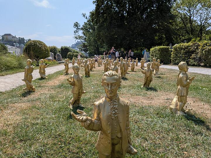 Ottmar H&ouml;rls Mozart-Plastiken noch einigerma&szlig;en vollst&auml;ndig Anfang August auf einer ausgetrockneten Wiese im Park von Schloss Mirabell.