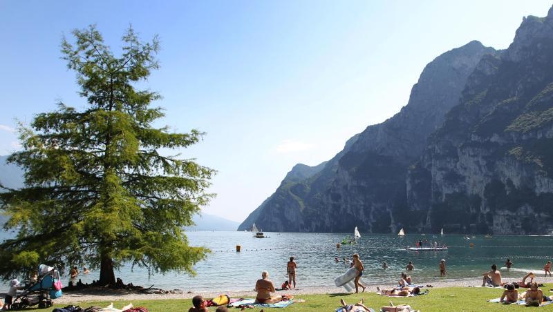 Touristen und Einheimische nehmen am Strand von Riva del Garda ein Sonnenbad. Touristen und Einheimische nehmen am Strand von Riva del Garda ein Sonnenbad.