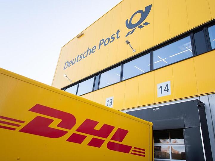 Logos der Deutschen Post und des Paketdienstes DHL. Foto: Tom Weller/dpa/Archivbild
