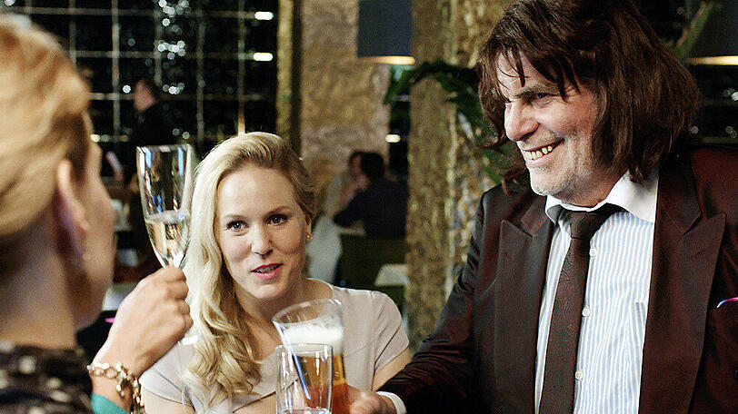 "Toni Erdmann": Toni Erdmann (Peter Simonischek) mischt sich in einer Bar ins Gespräch von Ines (Sandra Hüller) und Steph (Lucy Russell, M.)