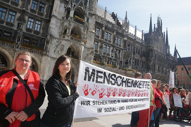 Erzieherinnen, Mütter und Sozialarbeiterinnen und Unterstützer bei Menschenkette am Marienplatz in München.