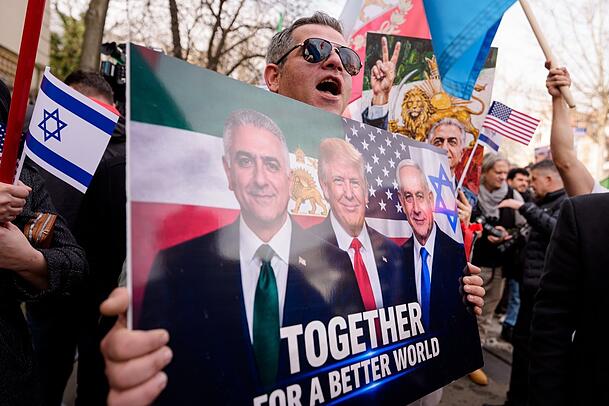Ein Mitglied der iranischen Gemeinde hält ein Plakat mit Abbildungen von von Irans exiliertem Kronprinzen Reza Pahlavi, US-Präsident Donald Trump und Israels Ministerpräsident Benjamin Netanjahu während einer Kundgebung vor der iranischen Botschaft in Bukarest. Ein Mitglied der iranischen Gemeinde hält ein Plakat mit Abbildungen von von Irans exiliertem Kronprinzen Reza Pahlavi, US-Präsident Donald Trump und Israels Ministerpräsident Benjamin Netanjahu während einer Kundgebung vor der iranischen Botschaft in Bukarest.