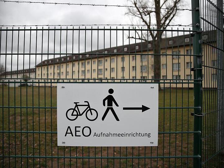 Ein Schild weist den Weg zum Eingangsbereich des Ankerzentrums für Flüchtlinge in Bamberg. Foto: Daniel Karmann/dpa/Archivbild