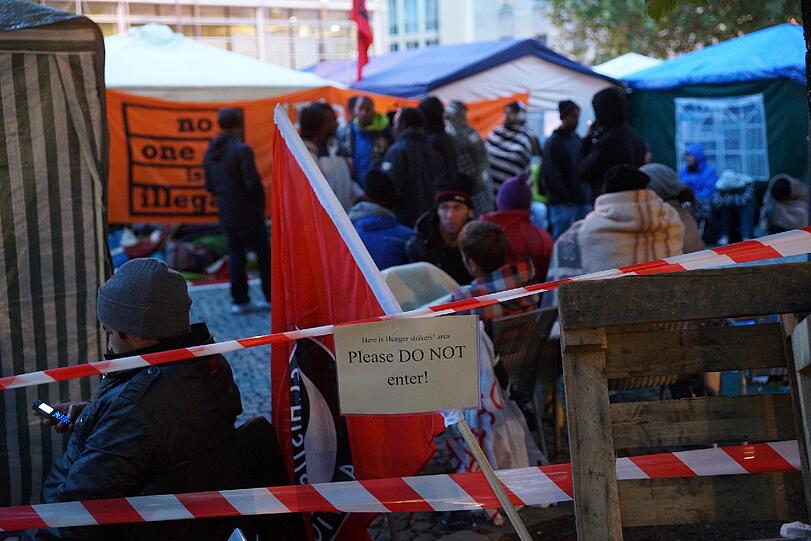Polizisten und Notärzte stehen um das Camp am Rindermarkt. Seit Dienstag trinken die Protestierenden nichts mehr.