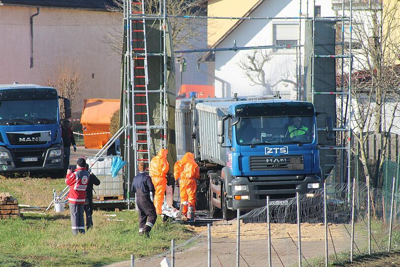 Männer in Schutzanzügen arbeiten am Sonntag auf dem Geflügel-Betrieb.