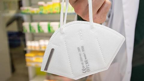 Ein Apotheker hält eine FFP2-Maske.