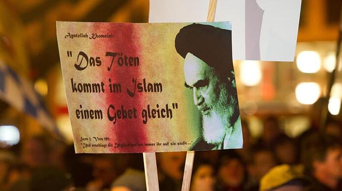 Ein Plakat mit der Aufschrift "Das Töten kommt im Islam einem Gebet gleich" wird bei einer Demonstration der islamfeindlichen Vereinigung "Bagida" von einem Teilnehmer gehalten.