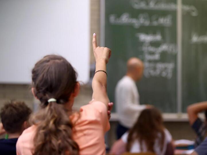 Eine Schülerin der fünften Klasse hebt im Unterricht den Finger. Foto: Daniel Karmann/Archiv