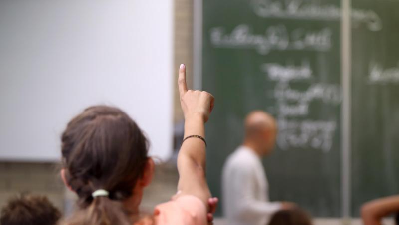 Eine Schülerin der fünften Klasse hebt im Unterricht den Finger. Foto: Daniel Karmann/Archiv